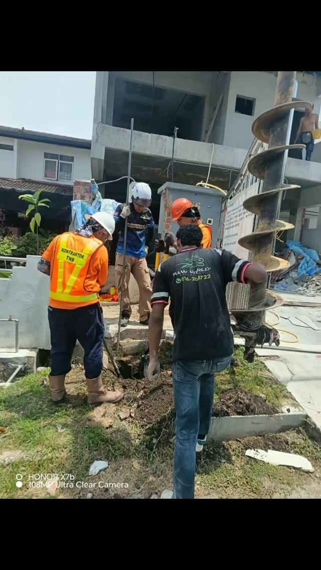 Crew drilling with earth auger